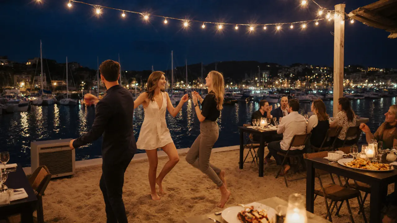Club 55 terrace at midnight with guests dancing on sand, harbor lights reflecting on water.