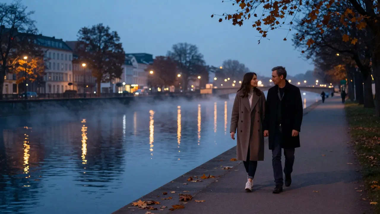 Couple walking peacefully along the Landwehrkanal at twilight, reflections on the water.