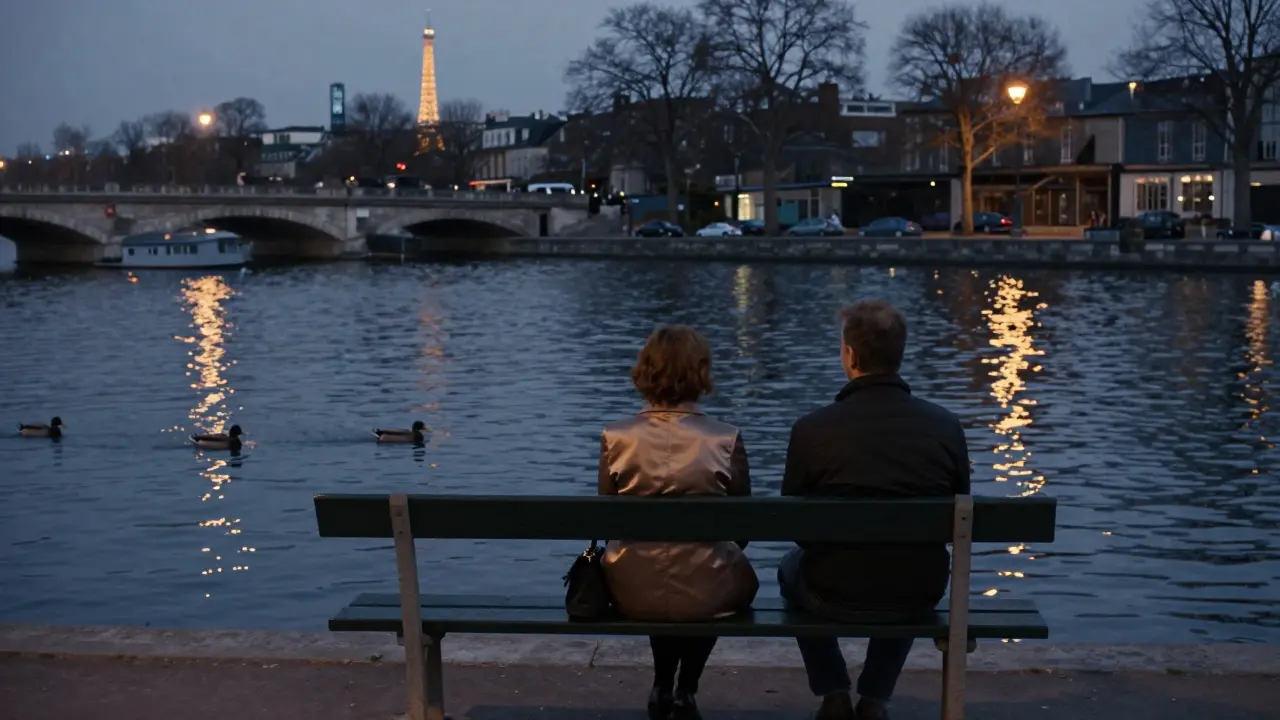 Man and woman sitting silently on a bench by the Canal Saint-Martin at dusk, ducks on the water.